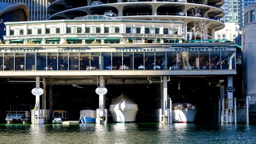 Boats docked under a restaurant building with a circular parking garage in Chicago